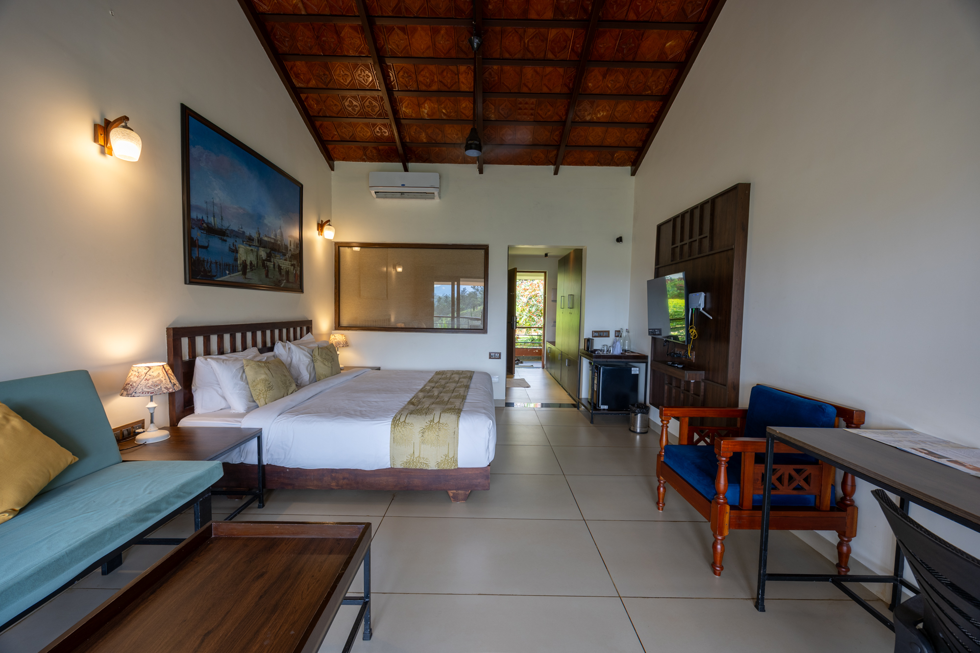 Pranavam Resort bedroom with modern amenities and warm décor